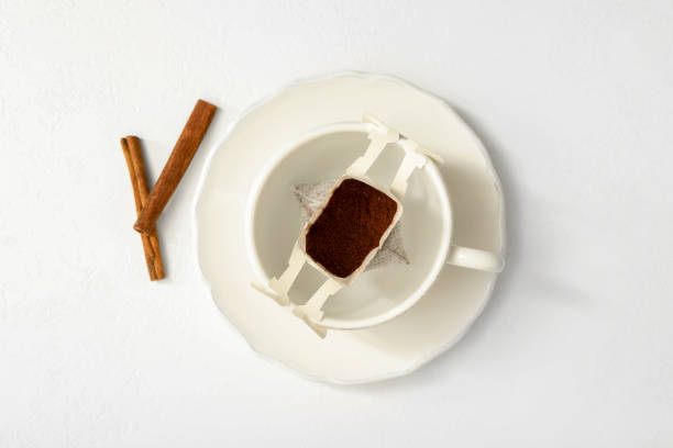istock Drip coffee in cup and cinnamon on white table, flat lay 1383826553
