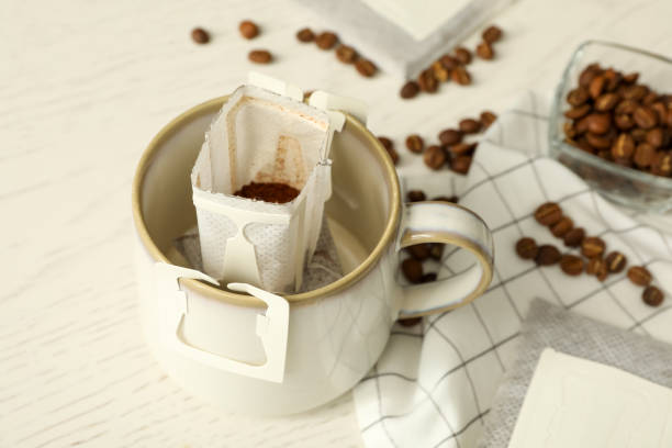 istock Drip coffee bag in cup on white table, closeup 1383826664