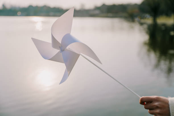 A paper windmill by the lake at dusk