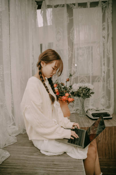 istock A beautiful asian girl who works on a computer in bed 1383829762