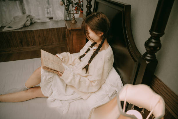 istock A beautiful asian girl reading in bed 1383829807
