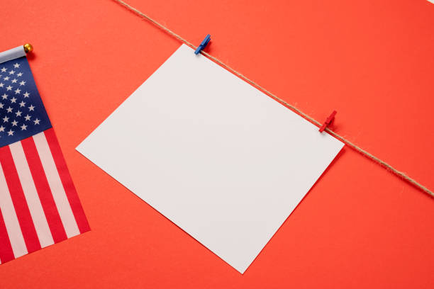 istock Blank white paper for mockup design with red and blue clips on red background 1383829917