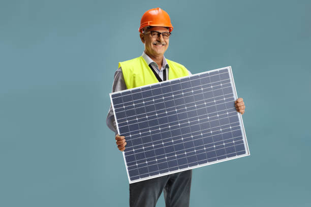 太陽光発電パネルを持つ笑顔の男性エンジニア - order repairing change telephone ストックフォトと画像
