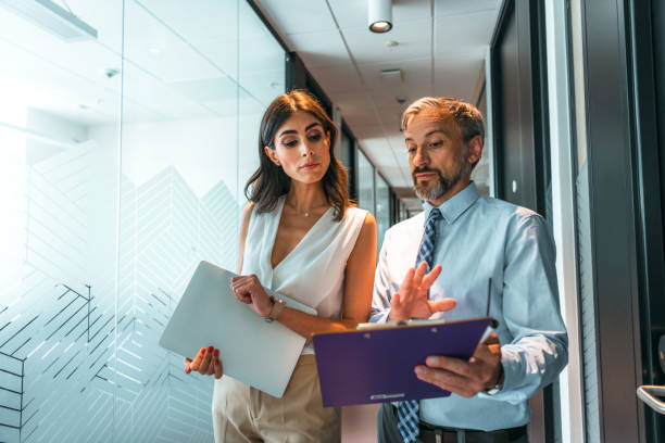 istock Business colleagues interacting with each other while walking in the corridor at office 1383832579