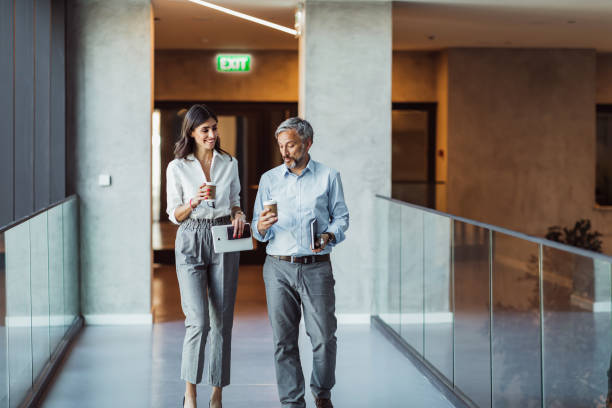 istock Business colleagues interacting with each other while walking in the corridor at office 1383833385