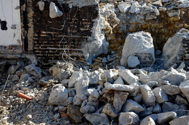 demolition of an apartment building. reinforcing concrete with wires looks out of the masonry and creates an apocalyptic scene. clearing work after the bombing. construction development in preparation, green, debris, waste, ruins, devastation, damage, demolished, gray, destroy, worker, phase, pile, white, man, men, army