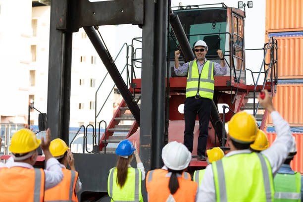 istock warehouse boss engineer standing on crane car with factory workers raise hand for congratulations in containers warehouse storage 1383834022