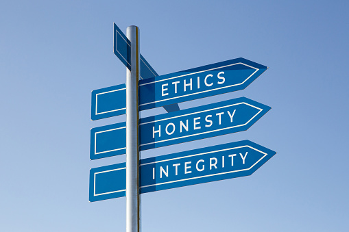 Ethics honesty integrity words on signpost isolated on sky background