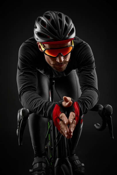 istock male cyclist riding road bicycle on black background 1383835092