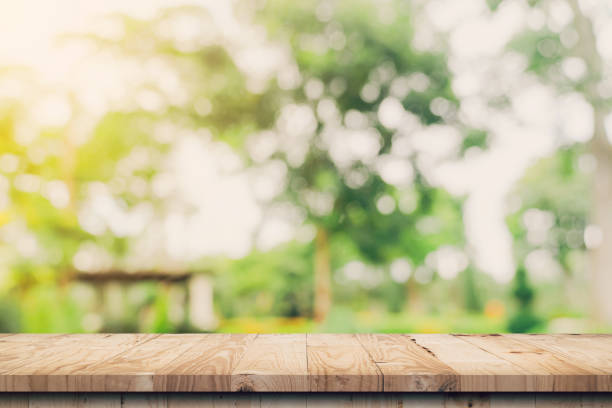 istock Empty wooden table top and Abstract blurred light bokeh and blur background of garden trees in sunlight. product display template with copy space. 1383841479