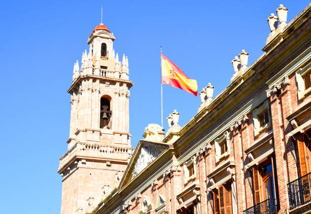 Spain flag on a building against a blue sky.