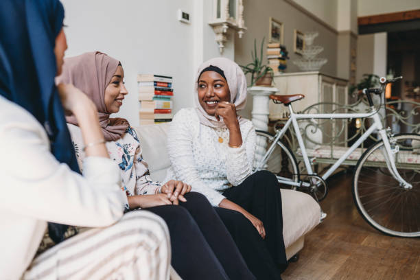 istock Three friends talking together sitting on the sofa at home 1383842094