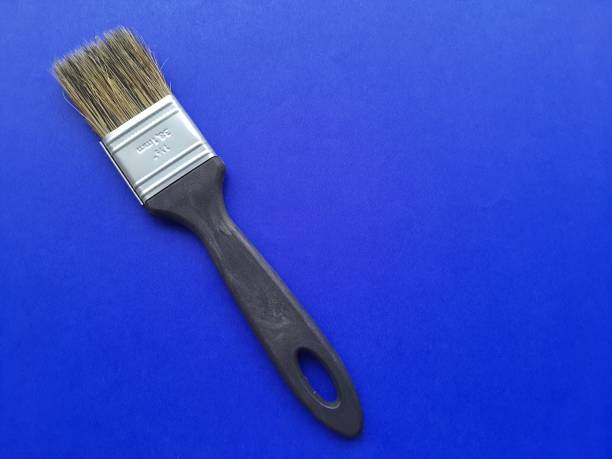 istock Painting : Paint brush isolated on blue background. 1383844263