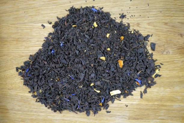istock Dry black tea isolated on wooden board. 1383844623