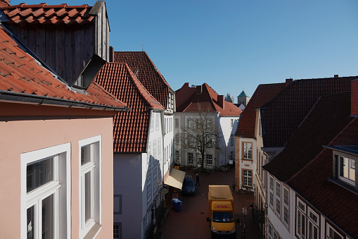 A view from the top down on a street with historic houses. The yellow van of the German delivery service DHL can be seen in the photo
