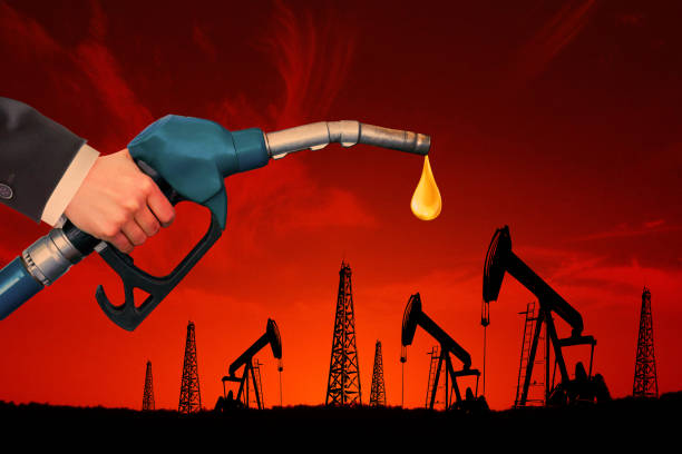 Oil dripping from a gasoline pump with oil field stock photo