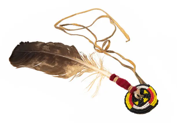 Eagle feather embroidered with pearls cords as Indian hair accessory isolated on white