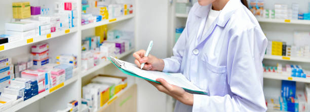 Asian woman pharmacist filling prescription in pharmacy drugstore stock photo