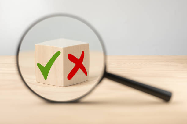 Analyze pros and cons. Magnifying glass with green tick and red cross in focus on wooden cube. consider all arguments pros and cons. Choices Tick Yes or No Choose Mark Decision Analyze pros and cons. Magnifying glass with green tick and red cross in focus on wooden cube. comparison concept for weigh all arguments. Pro and contra or Accept and Decline. pros and cons stock pictures, royalty-free photos & images