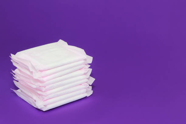 assorbenti bianchi da donna per le mestruazioni su sfondo viola molto peri - sanitary napkin foto e immagini stock