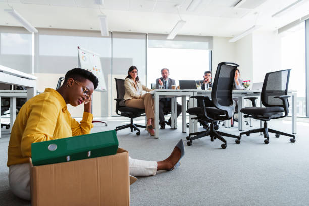 istock Woman office worker is unhappy with being fired from a company packing things into cardboard boxes. 1383859384