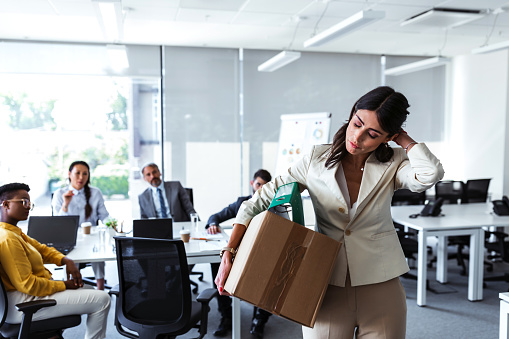 Stress of business woman packing brown cardboard box her belonging after resign and signing cancellation contract letter, Change of job unemployment or resignation concept