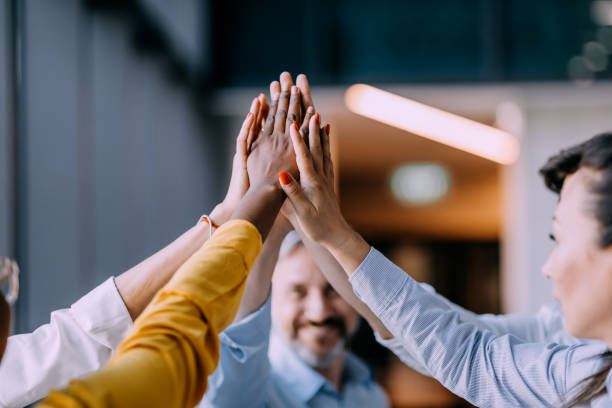 istock Cooperation and teamwork in business team with many hands stacked on a pile 1383860748