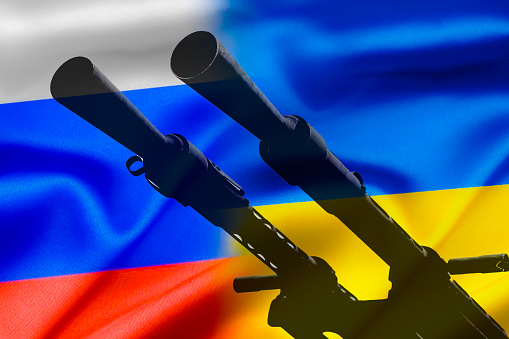 Conflicto militar entre Rusia y Ucrania, Un arma contra el fondo de dos banderas estatales de los estados en guerra. photo