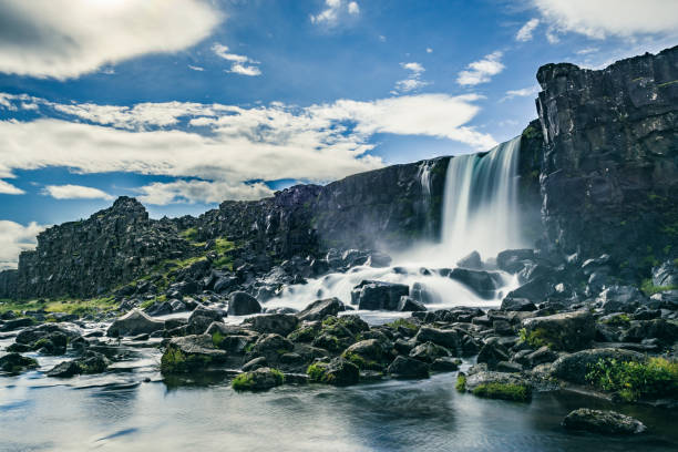 Öxarárfoss waterfall in Thingvellir National Park, Iceland during a beautiful summer day. The Oxarar river runs through the break line between two tectonic plates. The Öxarárfoss is a waterfall situated within Þingvellir National Park in Southwest Iceland.