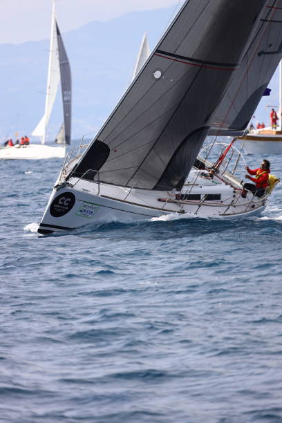 segelboote segeln bei windigem wetter im blauen wasser der ägäis - sailboat storm teamwork competition stock-fotos und bilder