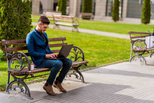 istock Young businessman work on laptop sitting on bench 1383868490