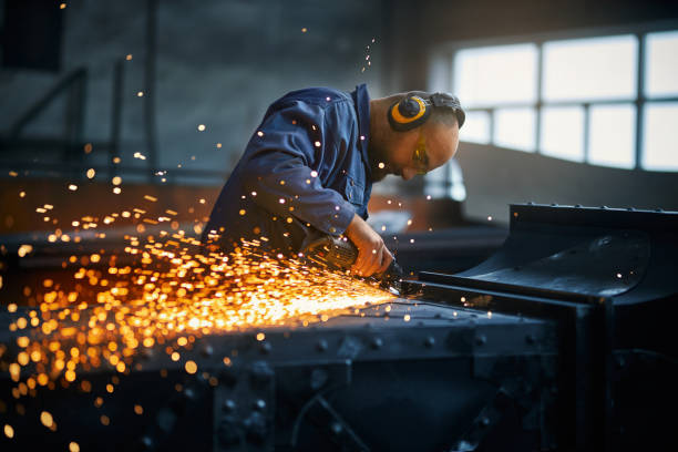 istock Worker creating fence near orange sparks in smithy. 1383873327