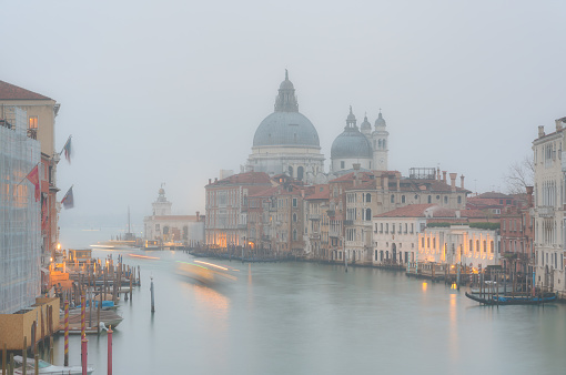 Mist drifts across the famous Grand Canal in Venice with the majestically-domed Santa Maria della Salute Basilica in the background