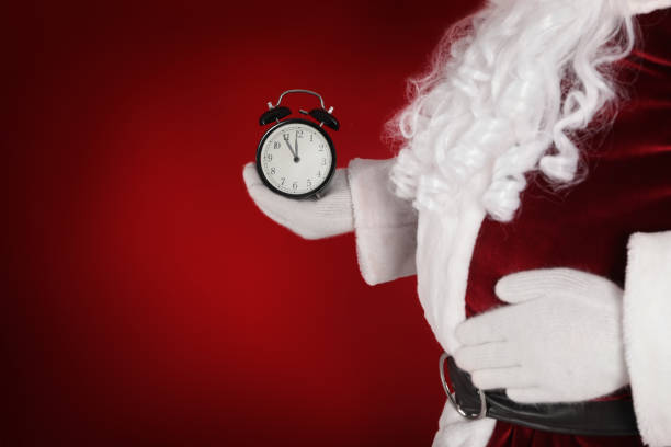 istock Santa Claus holding alarm clock on red background, space for text. Christmas countdown 1383878235