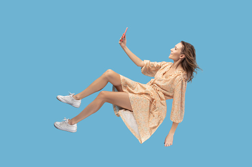mujer feliz levitando con el teléfono móvil, leyendo el mensaje chateando feliz en la red social en línea photo