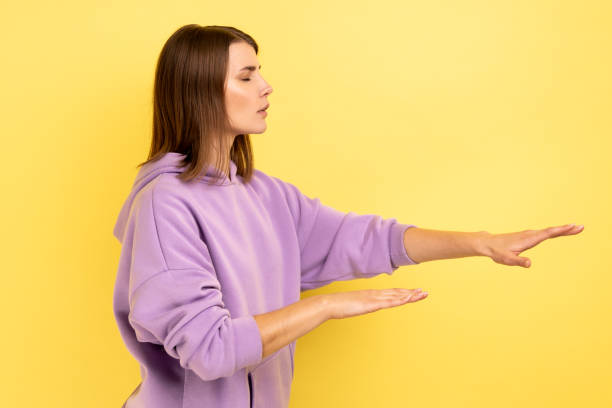 istock Woman with eyesight problems trying to move with closed eyes touching space around with hands. 1383881982