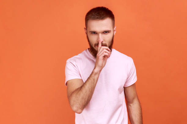 istock Man holding finger on lips making hush silence gesture, asking to keep secret, don't speak. 1383882072