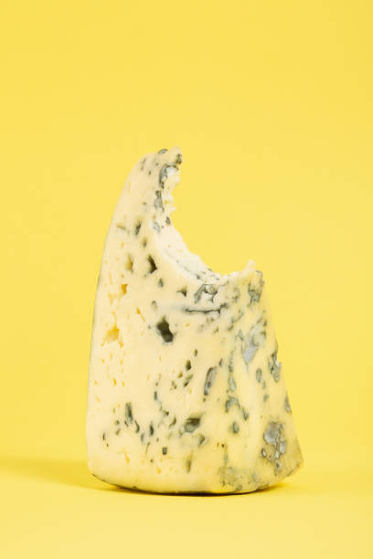 Bitten blue cheese on yellow background