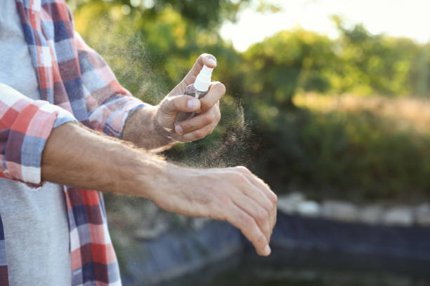 istock Man applying insect repellent onto hand outdoors, closeup 1383882441