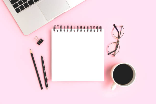 istock Workspace with laptop and notebook mockup on a pink background. 1383884030