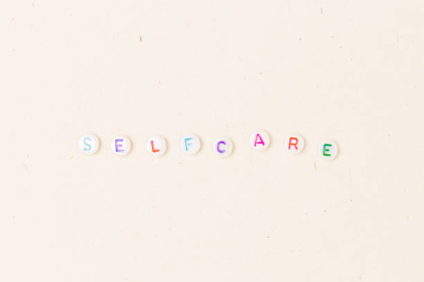 istock Selfcare. White round beads with colorful letters. 1383884165