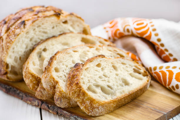 istock Close up of sliced wheat bread on board selective focus. 1383885157