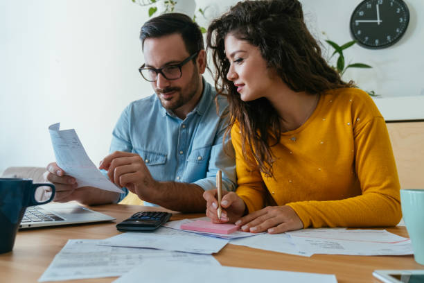 istock Smiling Loving Couple Paying Bills at Home 1383886927