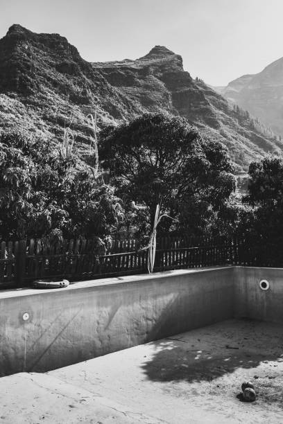 Abandoned swimming pool surrounded by mountains.