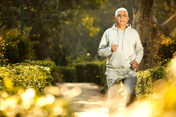 Old man walking at park stock photo