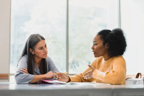 Photo of Teacher focuses on her student