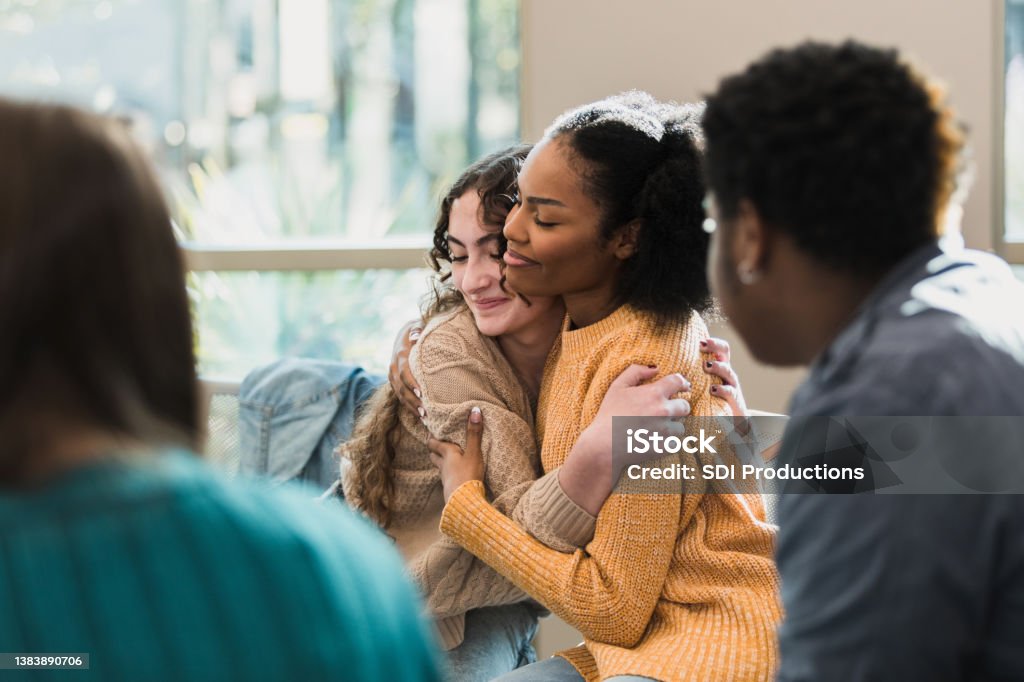 Friends console each other The beautiful friends hug and comfort each other after being vulnerable with their group. Teenager Stock Photo