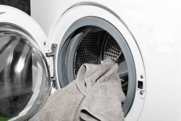 istock Unloading out the laundry from the washing machine. Loading clothes in a washing machine 1383895924