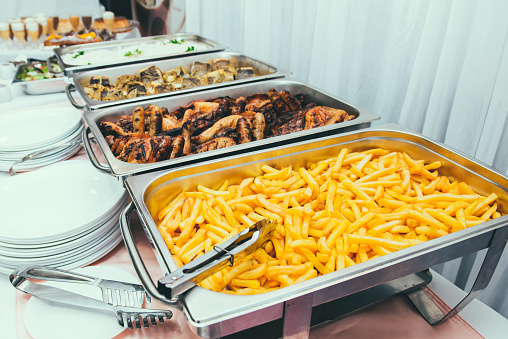 Cuisine Culinary Buffet Dinner Dining Food Celebration Party Concept. Trays with main meals - french fries chips, rice, meet and fish. Service at business meeting, weddings. Selective focus.