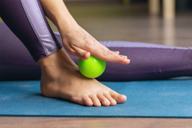 relaxation myofasciale des muscles hypermobiles du pied et de la cheville avec un rouleau massant, gros plan - massage ball photos et images de collection